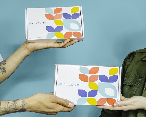 Two people holding Autumn's at home DNA test kits